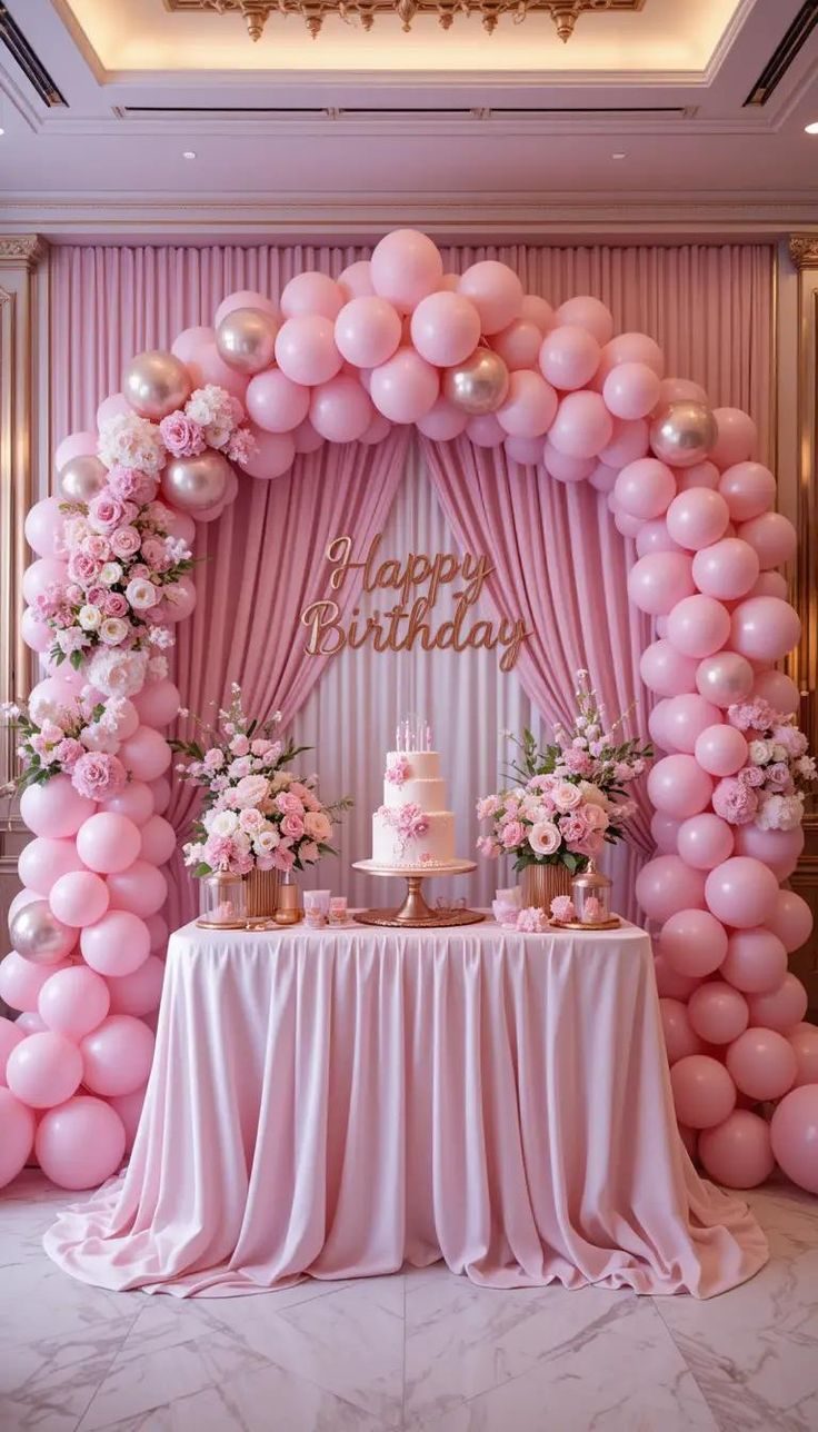 Pink birthday balloon and floral arch setup